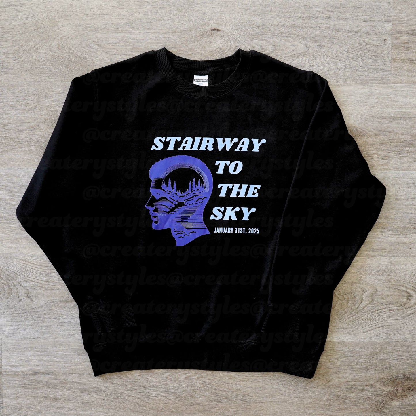 Black sweatshirt with a graphic design and text on a wooden surface
