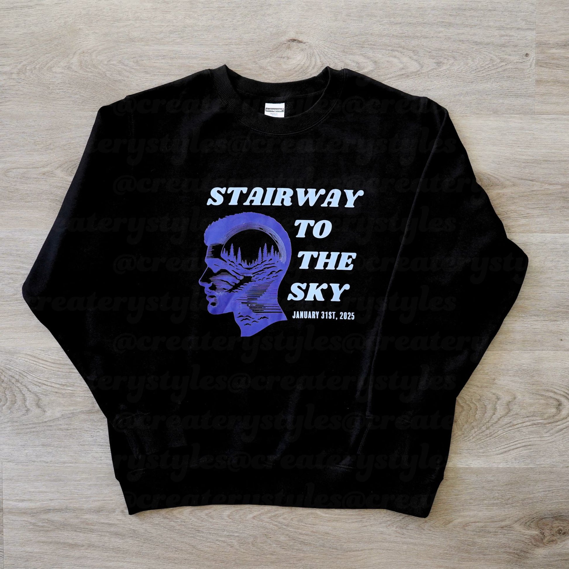 Black sweatshirt with a graphic design and text on a wooden surface